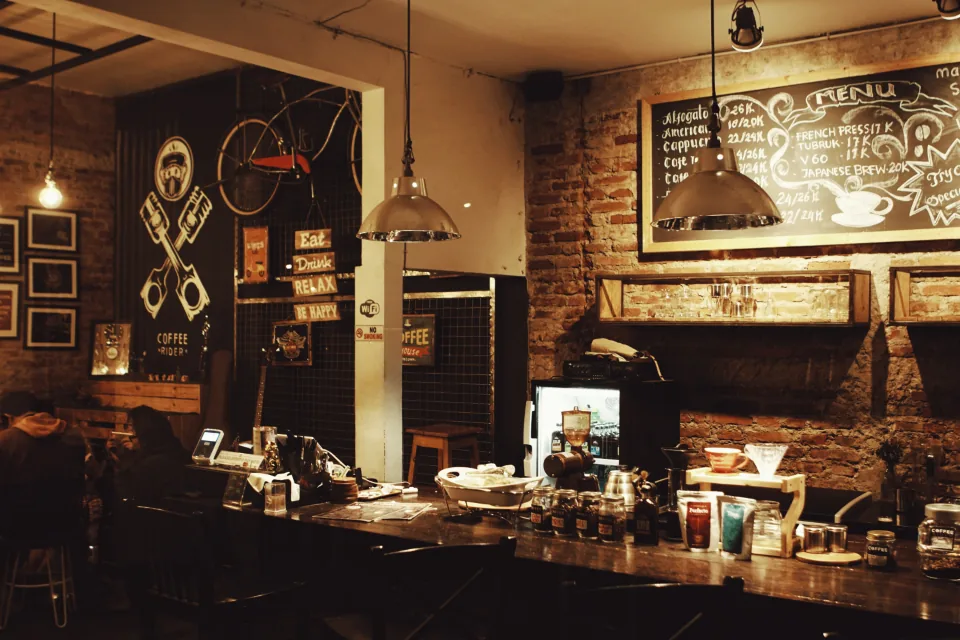 Warmly lit restaurant bar with chalkboard menus
