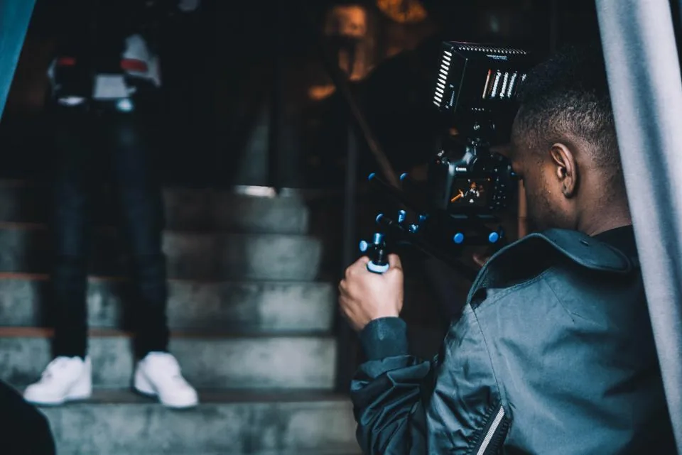 Videographer filming on a stairway with a camera on a handheld gimbal