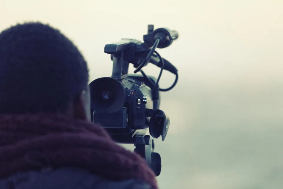 Videographer filming with a shoulder-mounted video camera